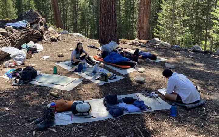 a group of students rest on pads during a backpacking course with outward bound